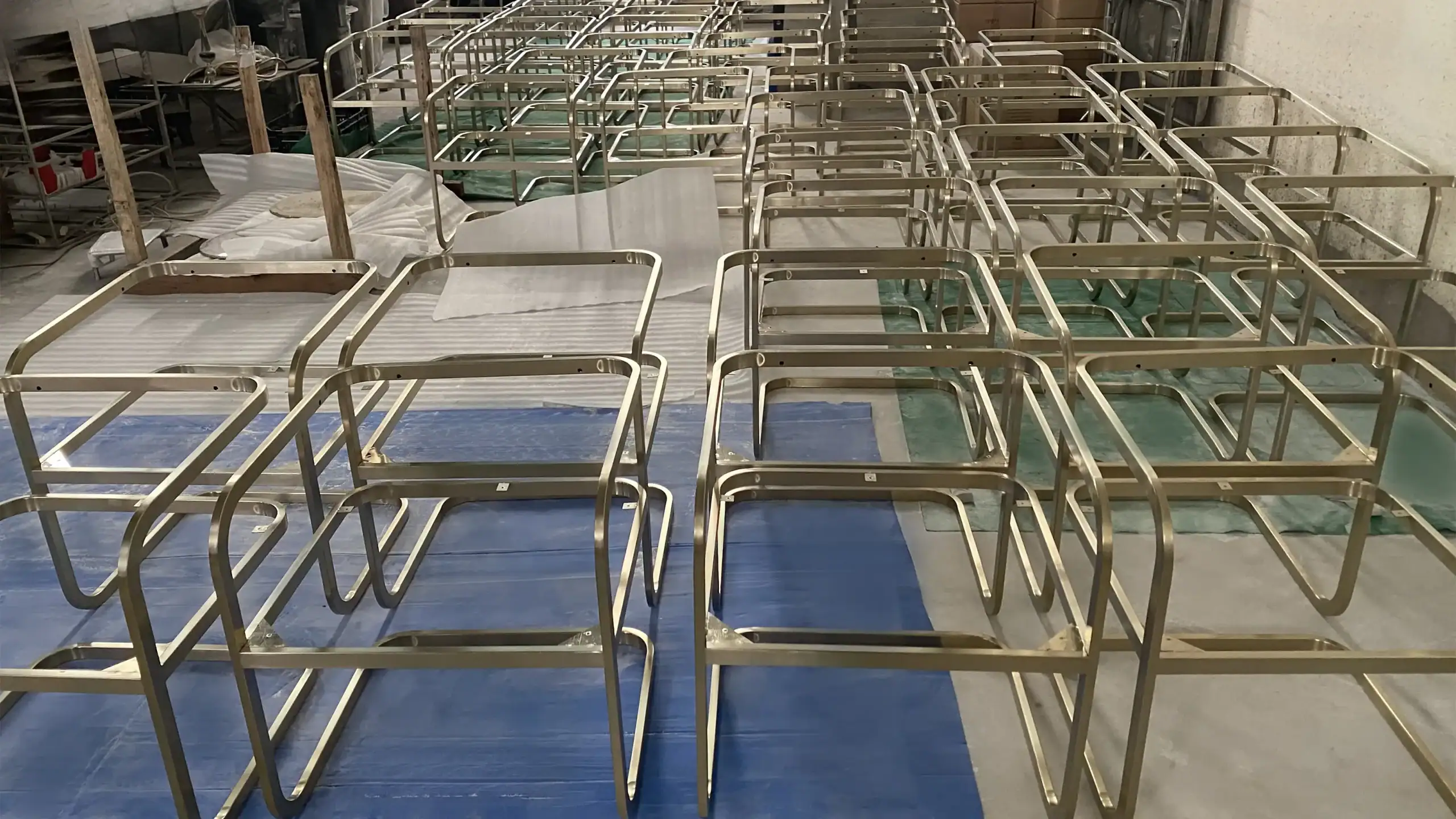 Finished metal chair frames (aluminum/stainless steel) ready for PVD coating, emphasizing clean welds and smooth surface preparation.