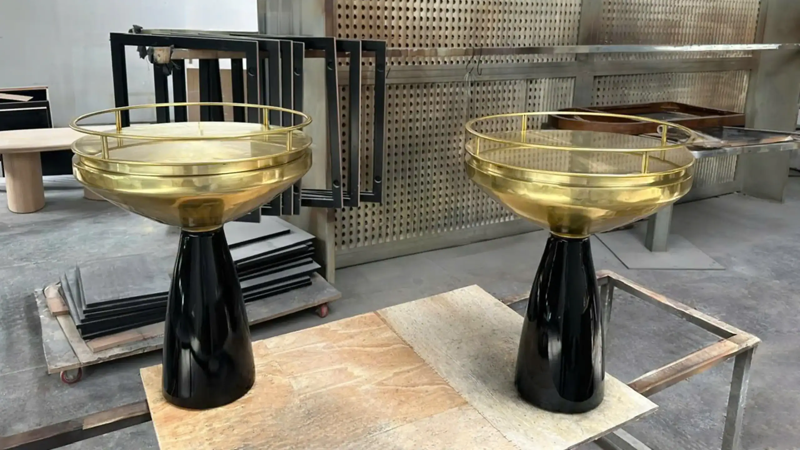 Luxury metal pedestal side tables with PVD gold finish and black lacquer base, showcasing high-end metal fabrication expertise.