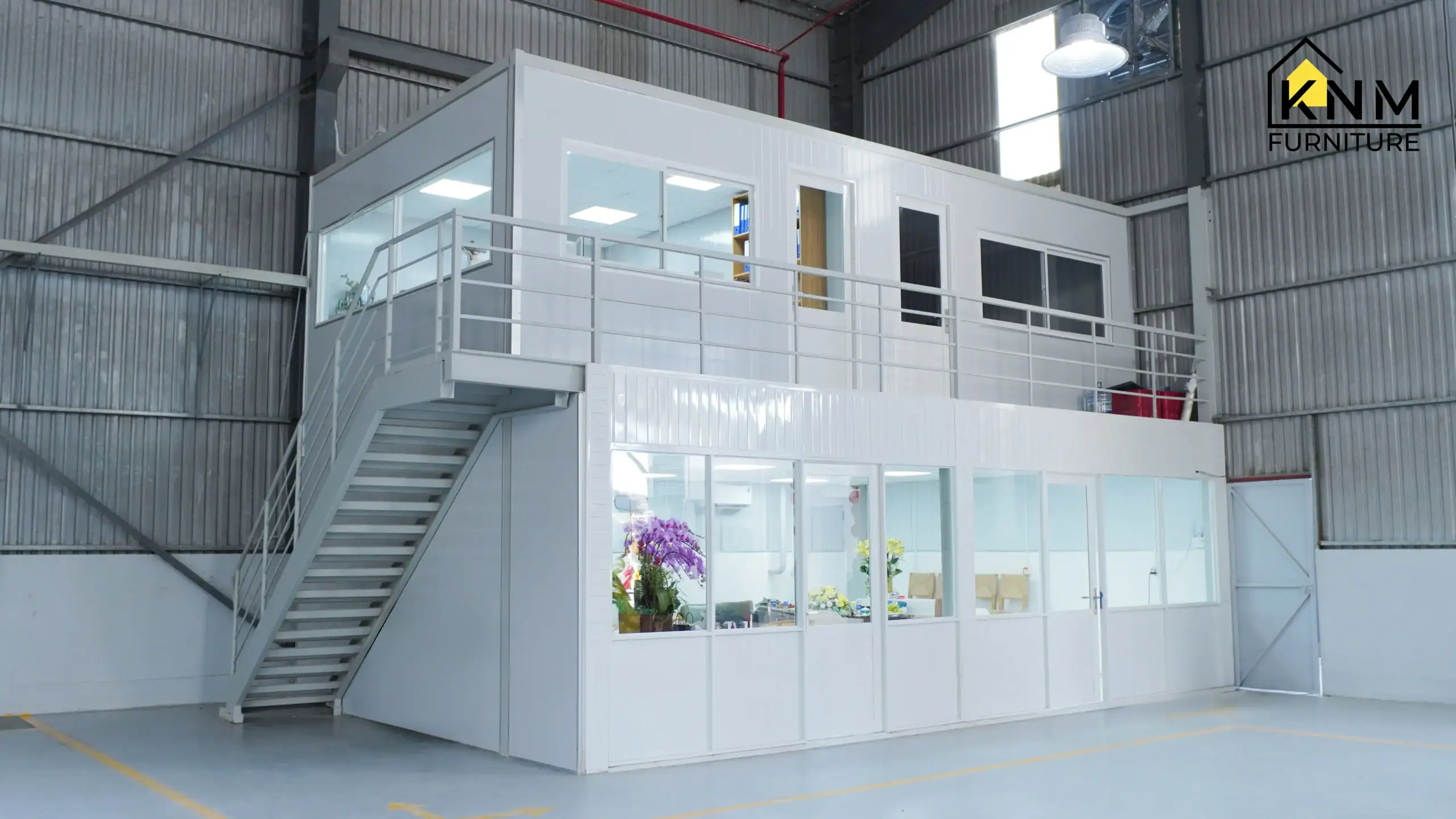 Modern, two-story quality control (QC) and project management office overlooking the main Khanom Furniture Vietnam production floor, demonstrating active supervision over all manufacturing stages.