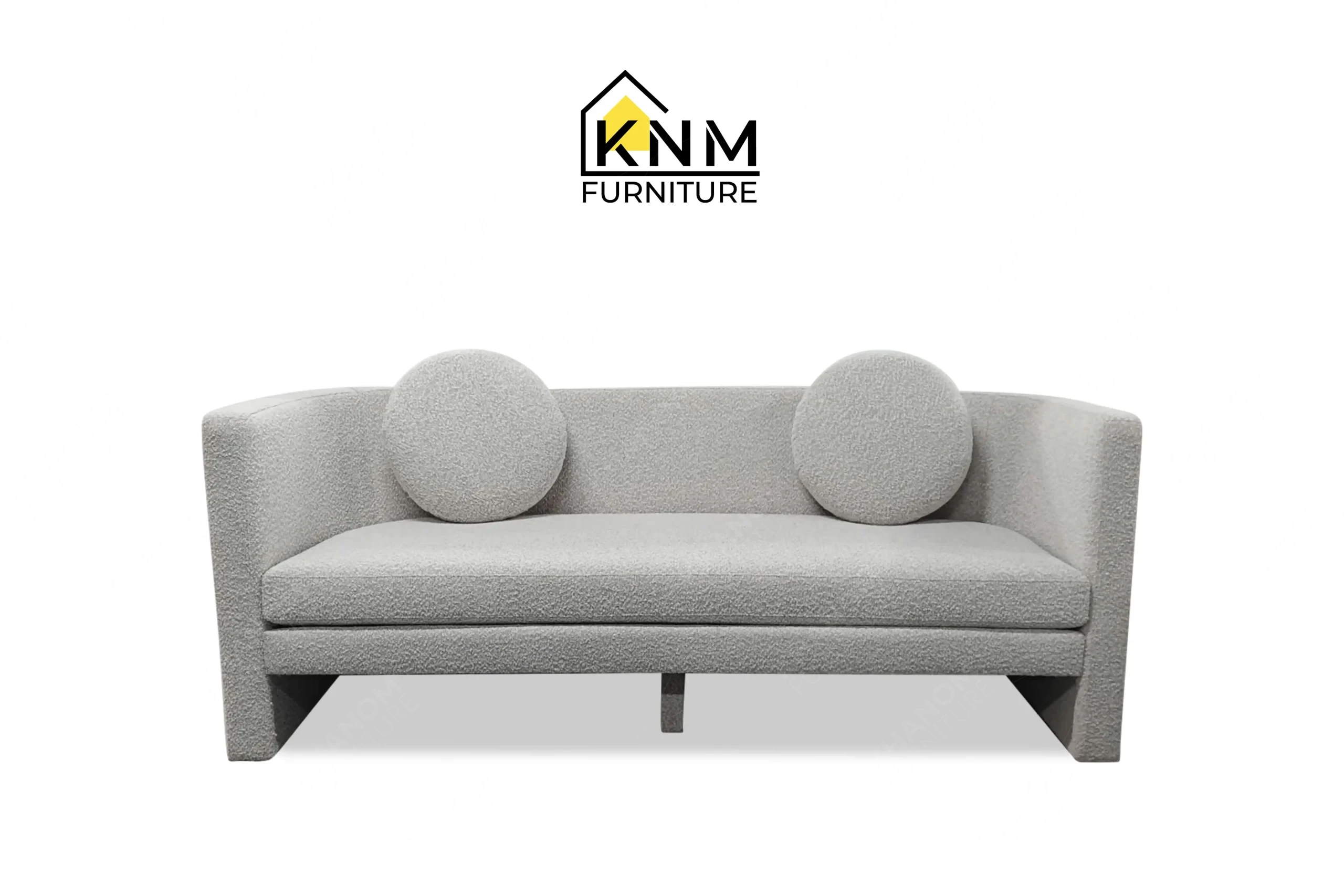 Front view of a bespoke upholstered suite daybed featuring grey boucle fabric and round pillows, custom crafted by Khanom Furniture (KNM Furniture), a renowned custom furniture manufacturer.