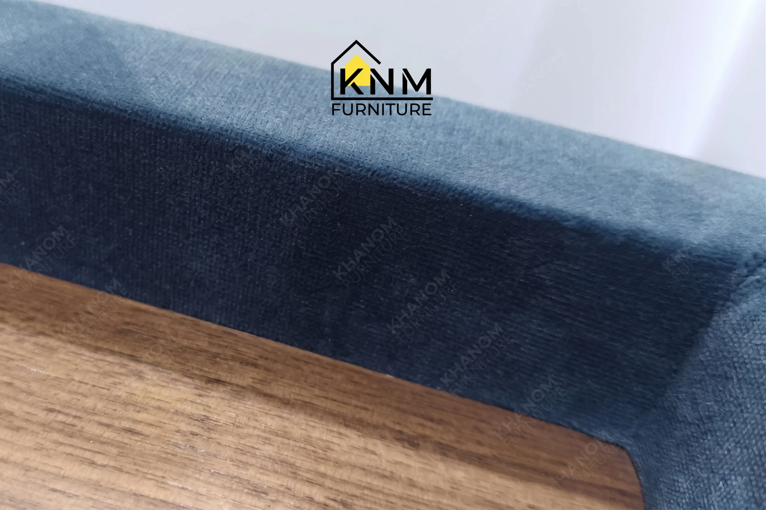 A craftsmanship close-up of the blue velvet channel tufted sectional from Khanom Furniture, highlighting the uniform tufting channels and seam integrity.
