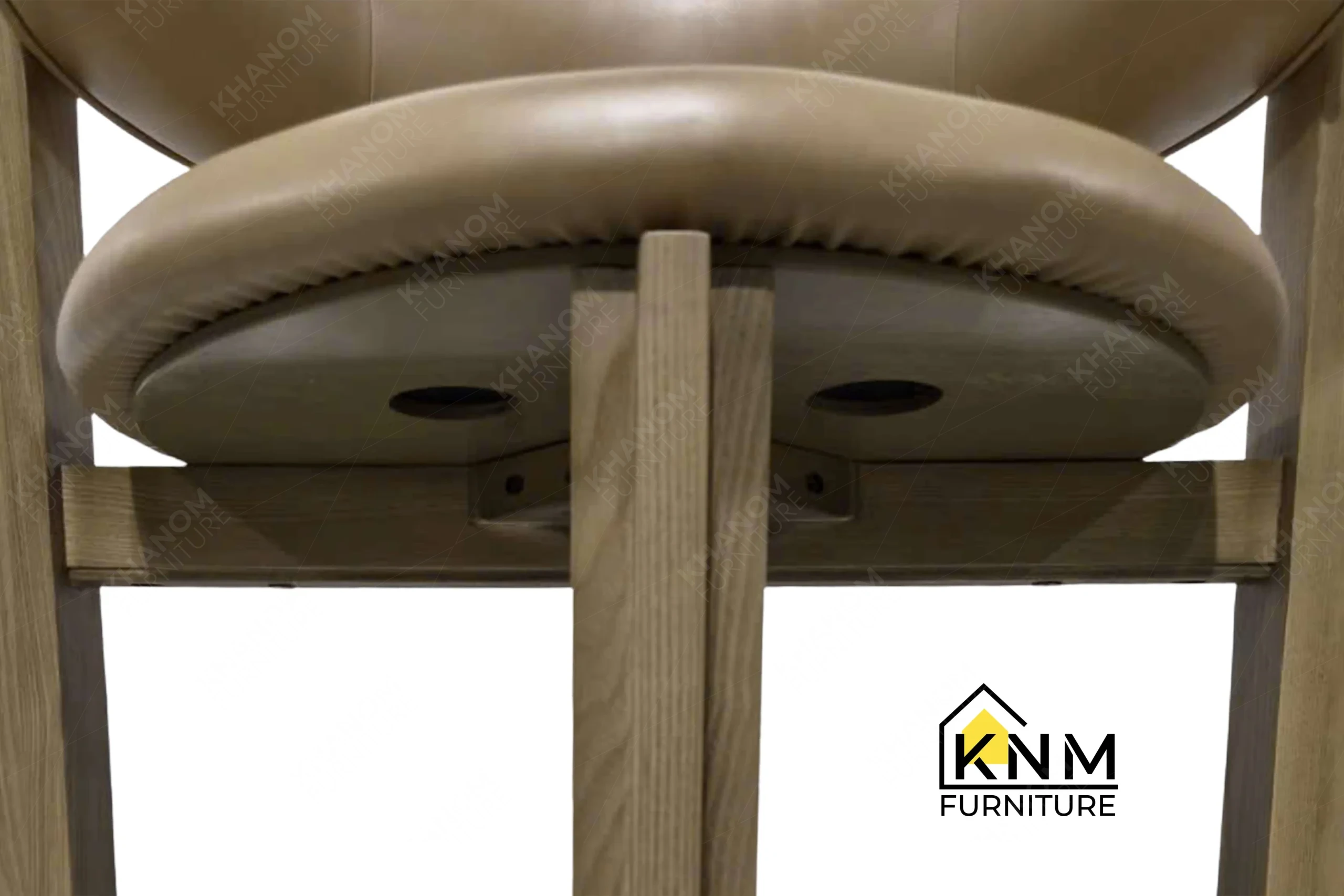 A detailed material zoom of the solid ash curved back dining chair by Khanom Furniture, showing the Savannah Cream fabric texture adjacent to the light ash wood.