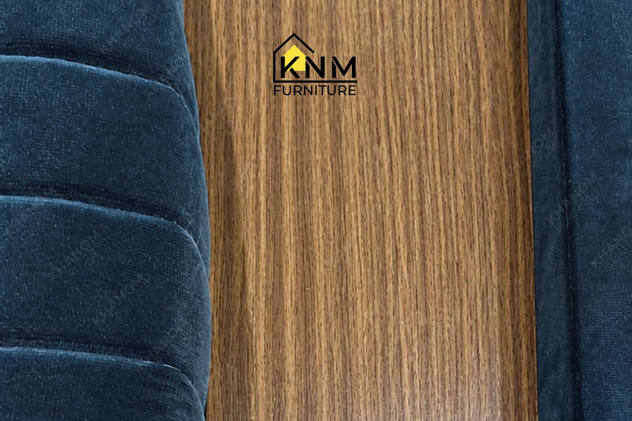 The surface texture detail of the blue velvet channel tufted sectional manufactured by Khanom Furniture reveals the custom-finished walnut veneer grain.
