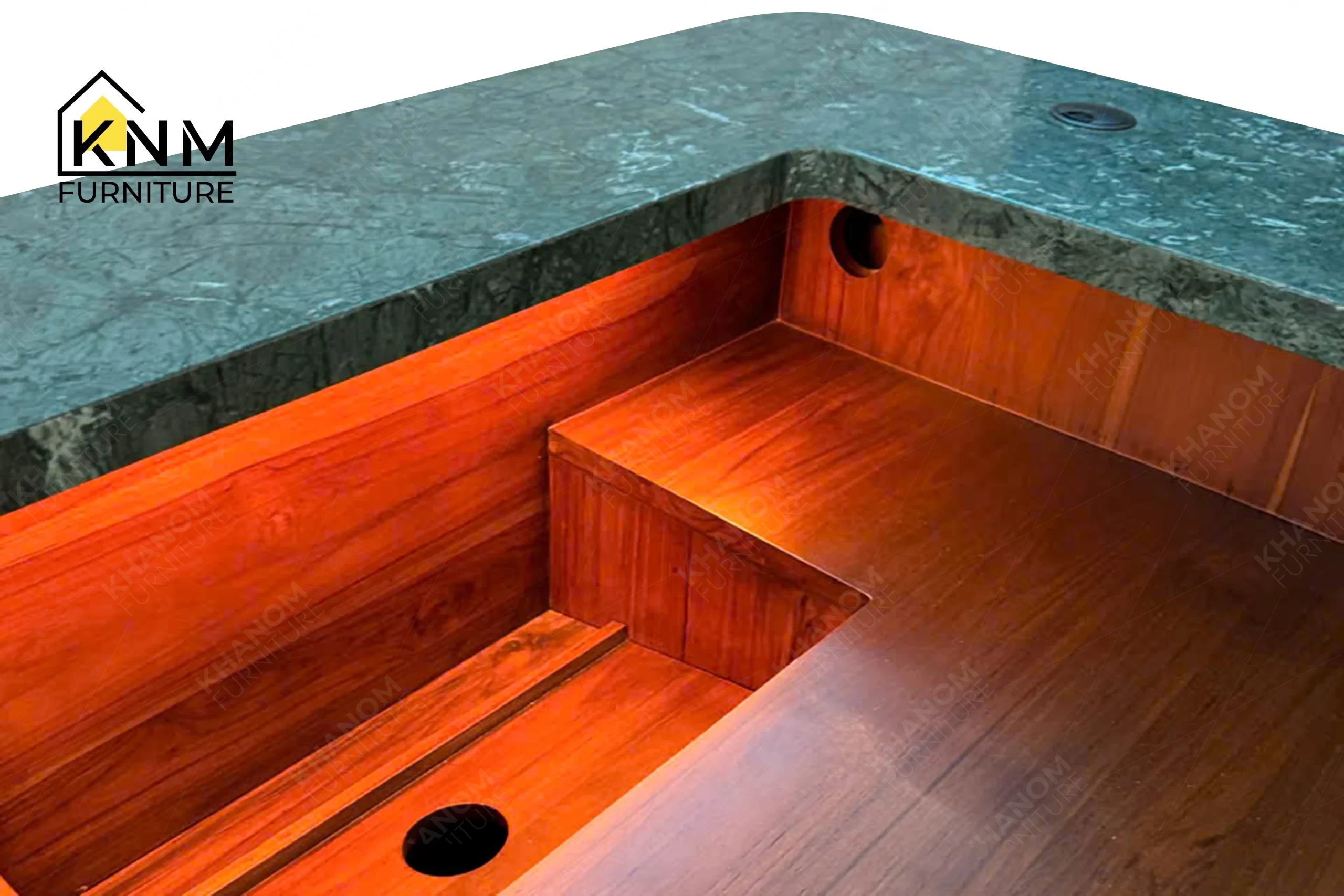 A detailed material zoom of the stone top solid wood reception desk by Khanom Furniture, showing the green stone surface adjacent to the solid wood frame.