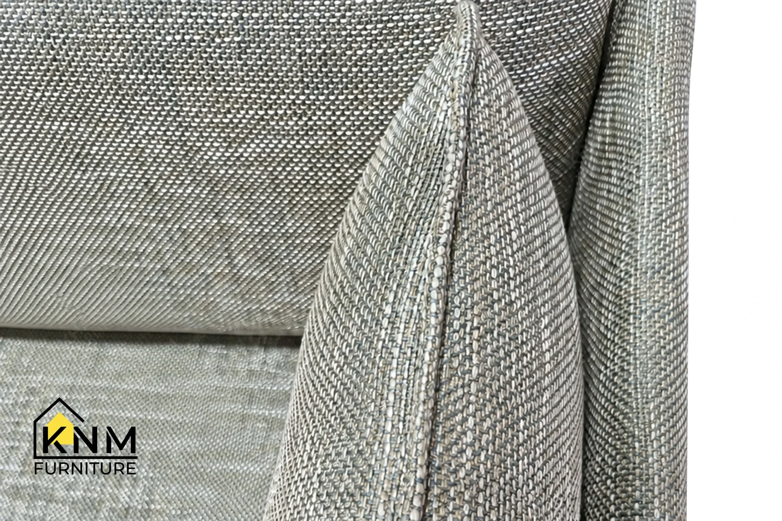 A detailed material zoom of the powder-coated steel lounge sofa by Khanom Furniture, showing the Architex fabric adjacent to the leather tabs and metal frame.