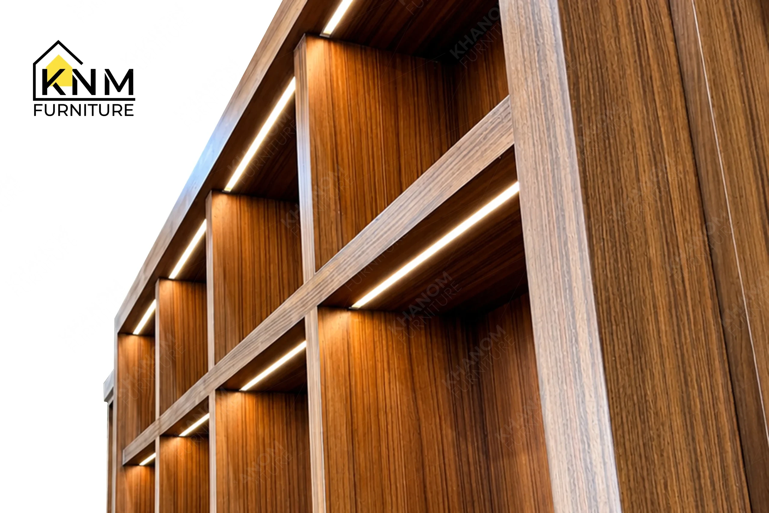 A technical detail of the teak veneer rattan display cabinet from Khanom Furniture, describing the concealed LED routing and fluted base joinery.