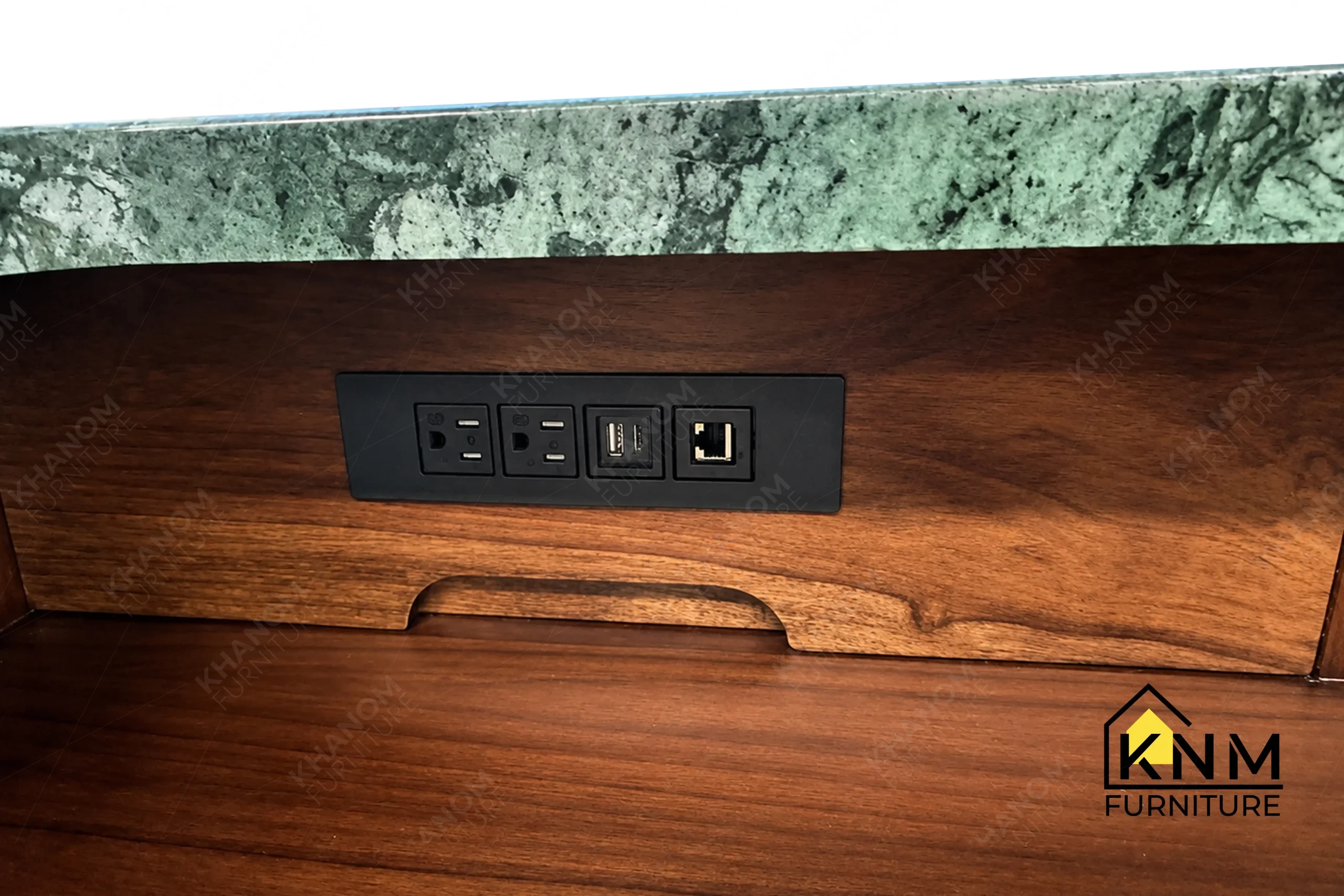 The other surface texture detail of the stone top solid wood reception desk manufactured by Khanom Furniture reveals the integrated LED task lighting and power modules.