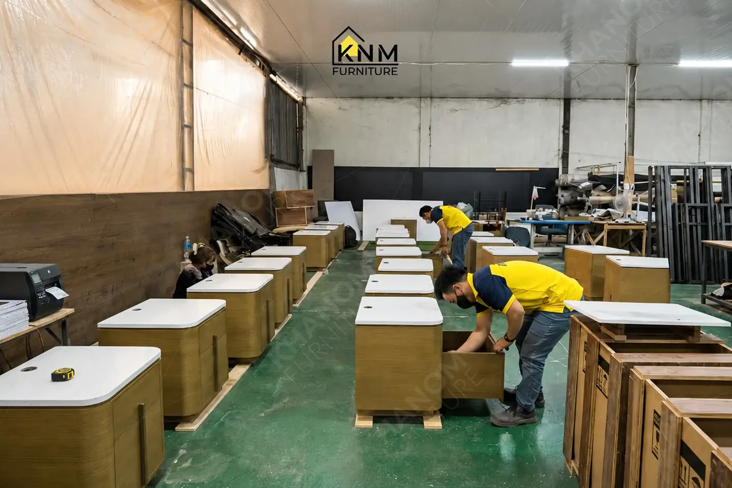 A row of identical night stand cabinets on the mass production assembly line at Khanom Furniture (KNM Furniture), a leading furniture factory Vietnam.