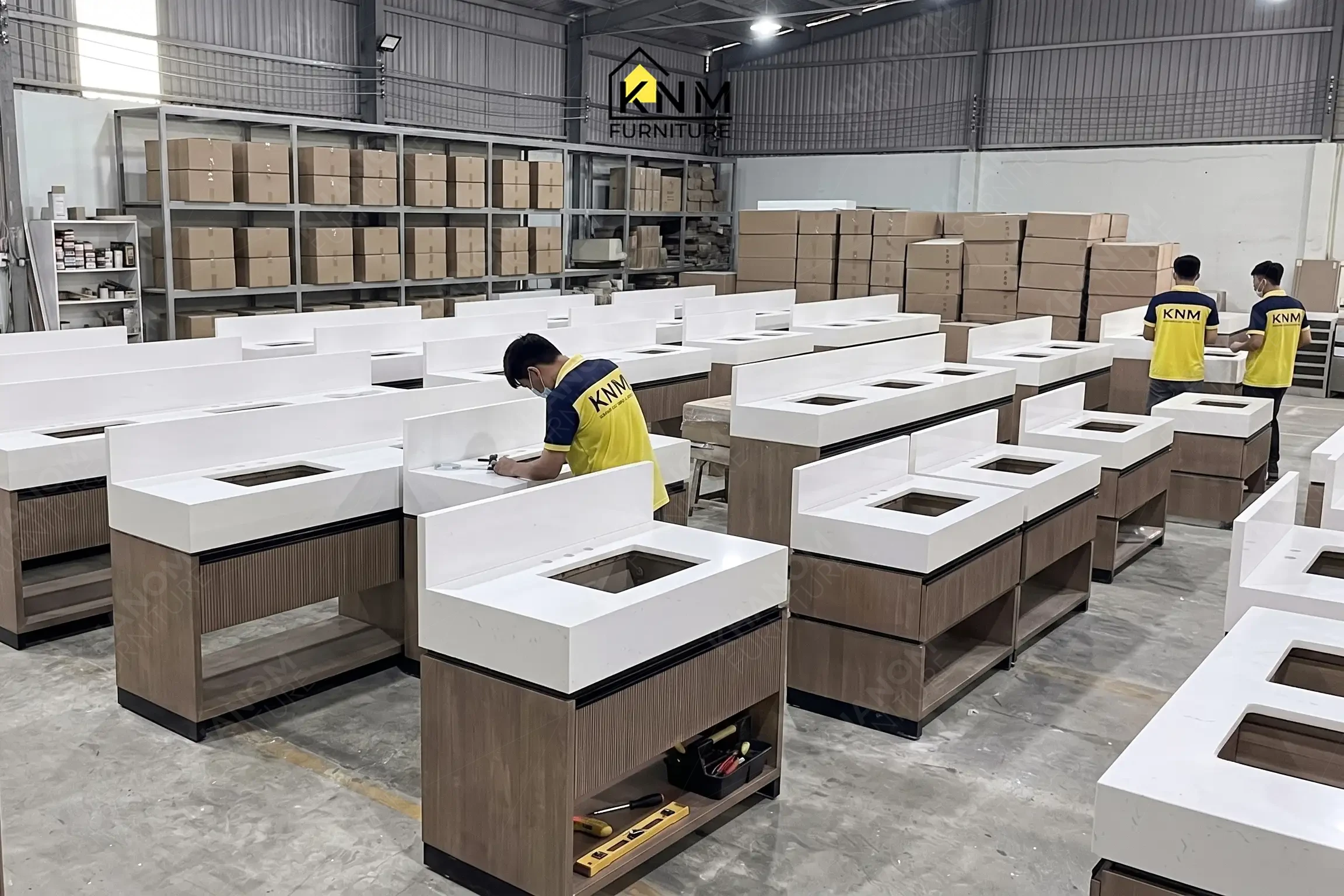 A row of identical vanities cabinets on the mass production assembly line at Khanom Furniture (KNM Furniture), a leading furniture factory Vietnam.