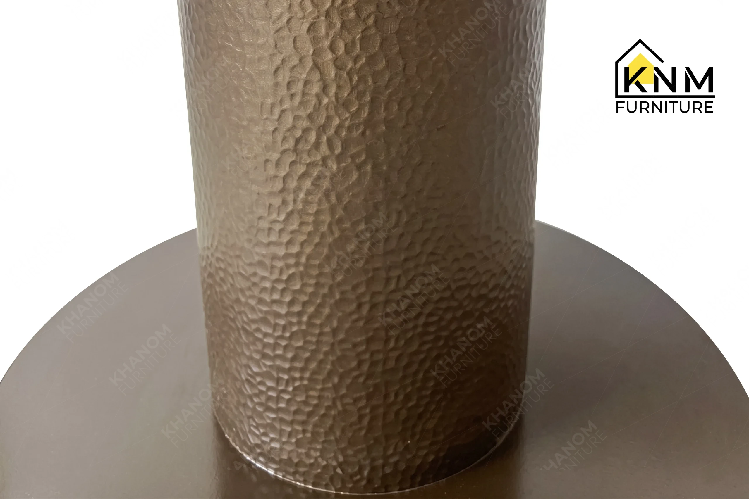 A detailed material zoom of the stone top metal pedestal dining table by Khanom Furniture, showing the gloss Tuffskin finish on the local Taj Mahal stone.