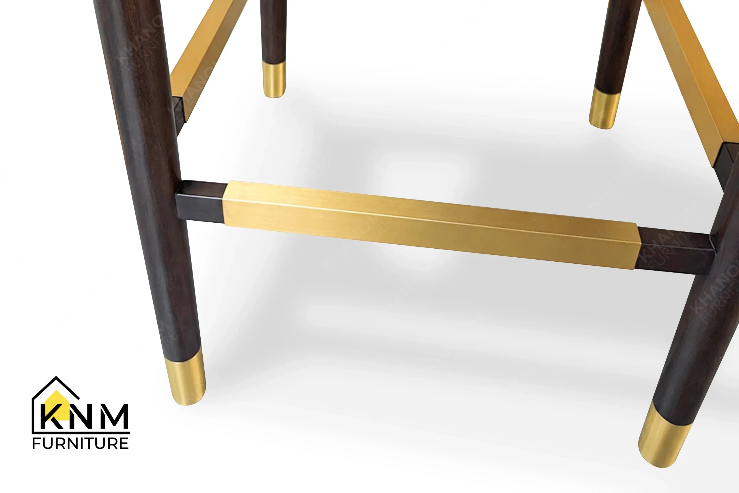 A technical detail of the Forest Green leather split back barstool from Khanom Furniture, describing the Antique Brass plated metal sabot on the hardwood leg.