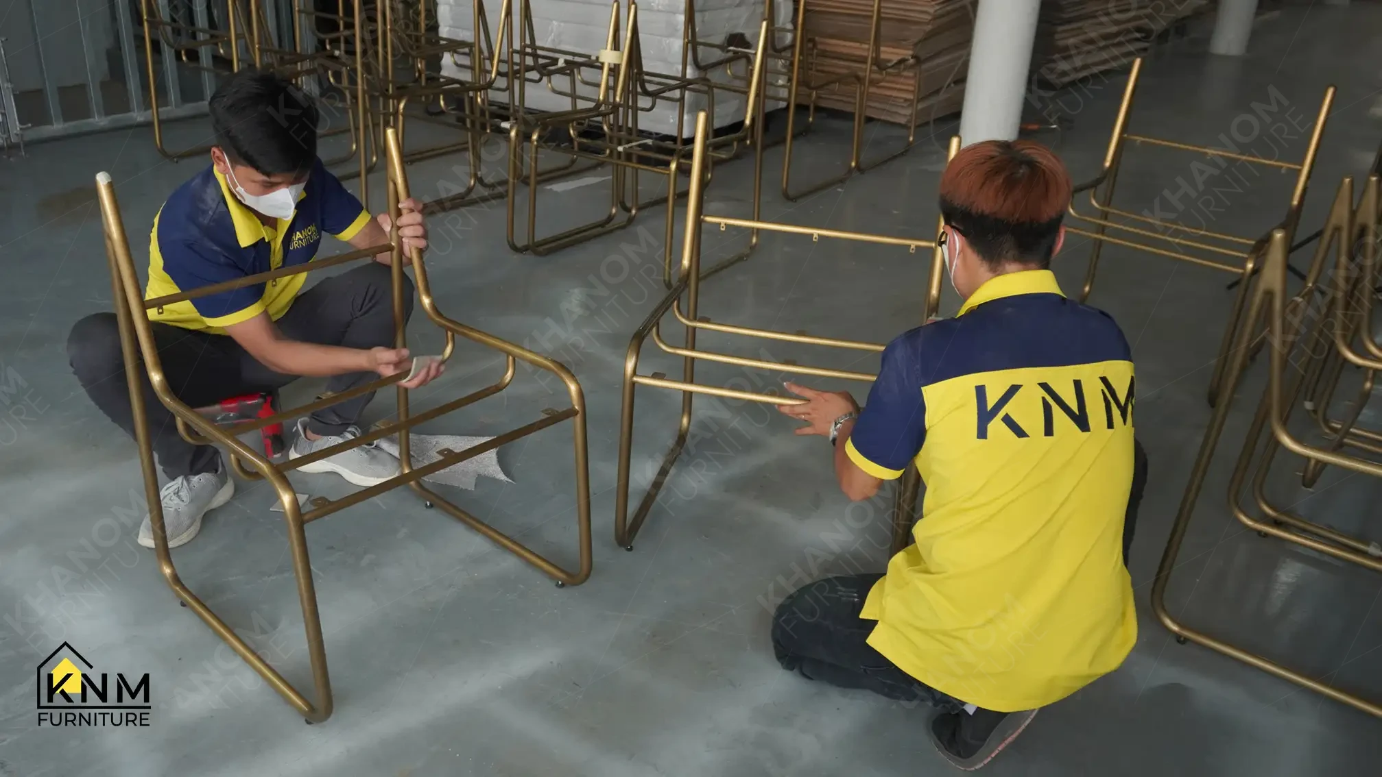 Technicians at Khanom Furniture (KNM) conducting manual surface preparation on batch produced gold metal chair frames at our metal factory Vietnam.
