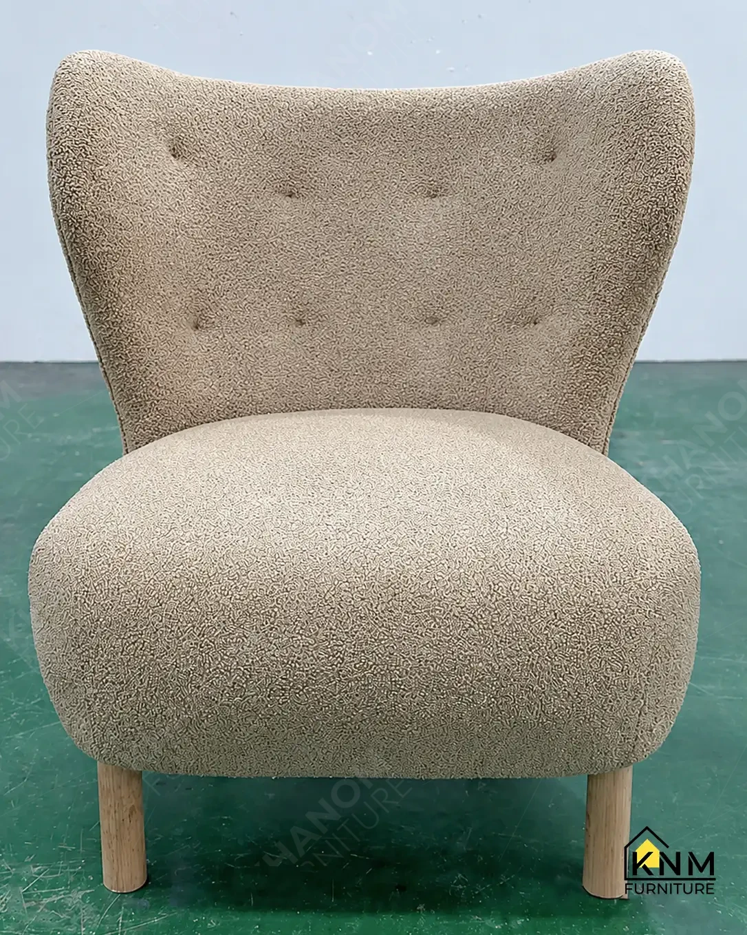 Tan boucle wingback lounge chair with button-tufted back and turned wood legs, finished hospitality seating unit by Khanom Furniture (KNM Furniture) Vietnam