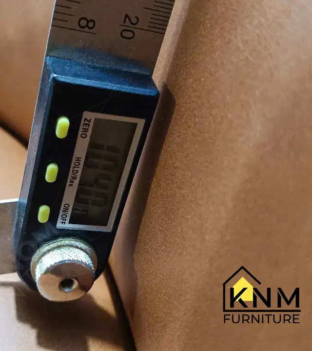 Digital protractor angle gauge measuring the backrest angle of a brown leather upholstered chair against specification during Khanom Furniture (KNM Furniture) pre-shipment QC inspection, steel rule visible.