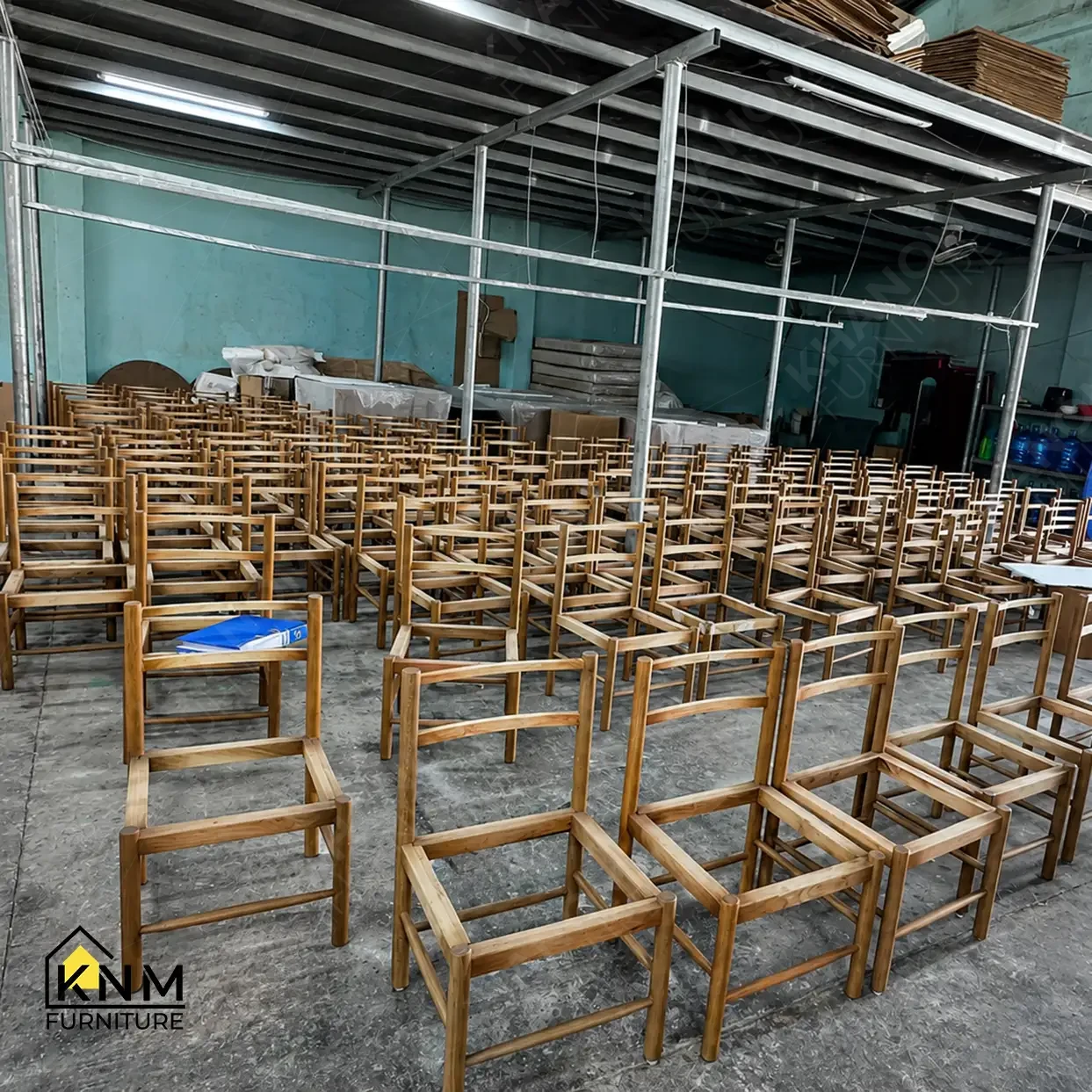 Rows of unupholstered solid wood dining chair frames staged on factory floor awaiting upholstery at Khanom Furniture (KNM Furniture), a contract furniture factory Vietnam