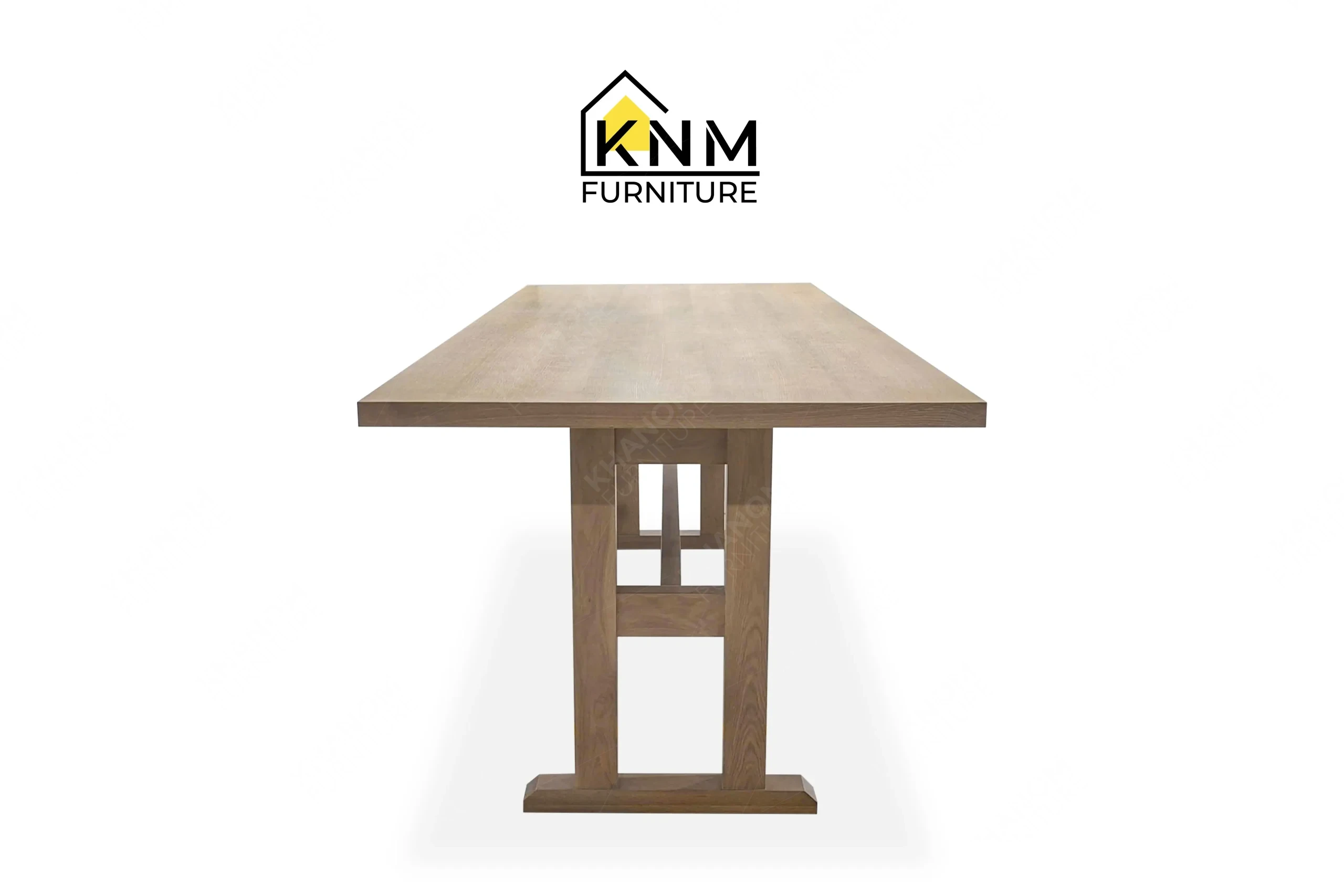 The side profile of the 120-inch solid oak communal table highlights the sturdy oak trestle base specified by Khanom Furniture.