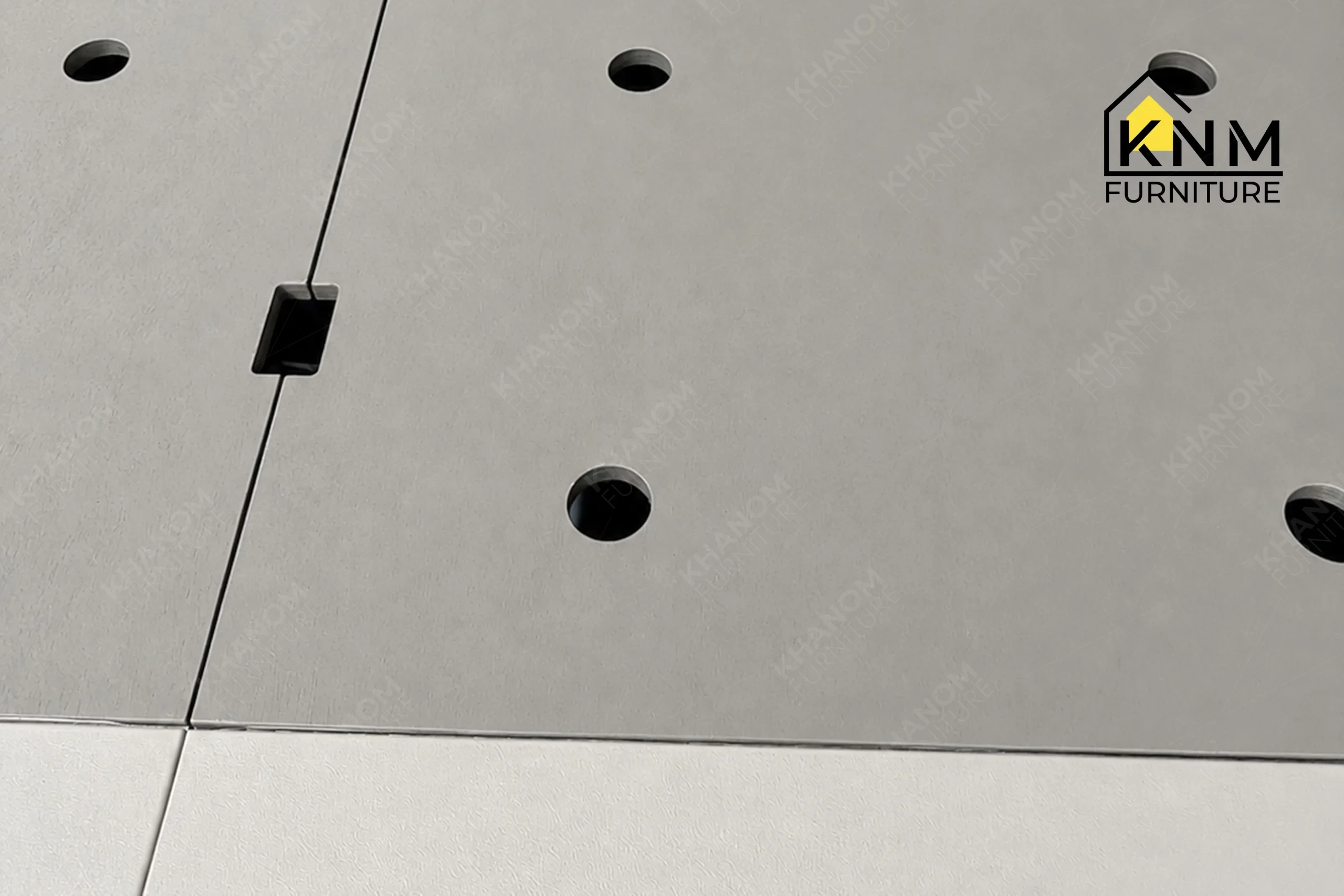 A detailed material zoom of the upholstered hotel bed base and headboard by Khanom Furniture, showing the self-welt detail on the cotton fabric.