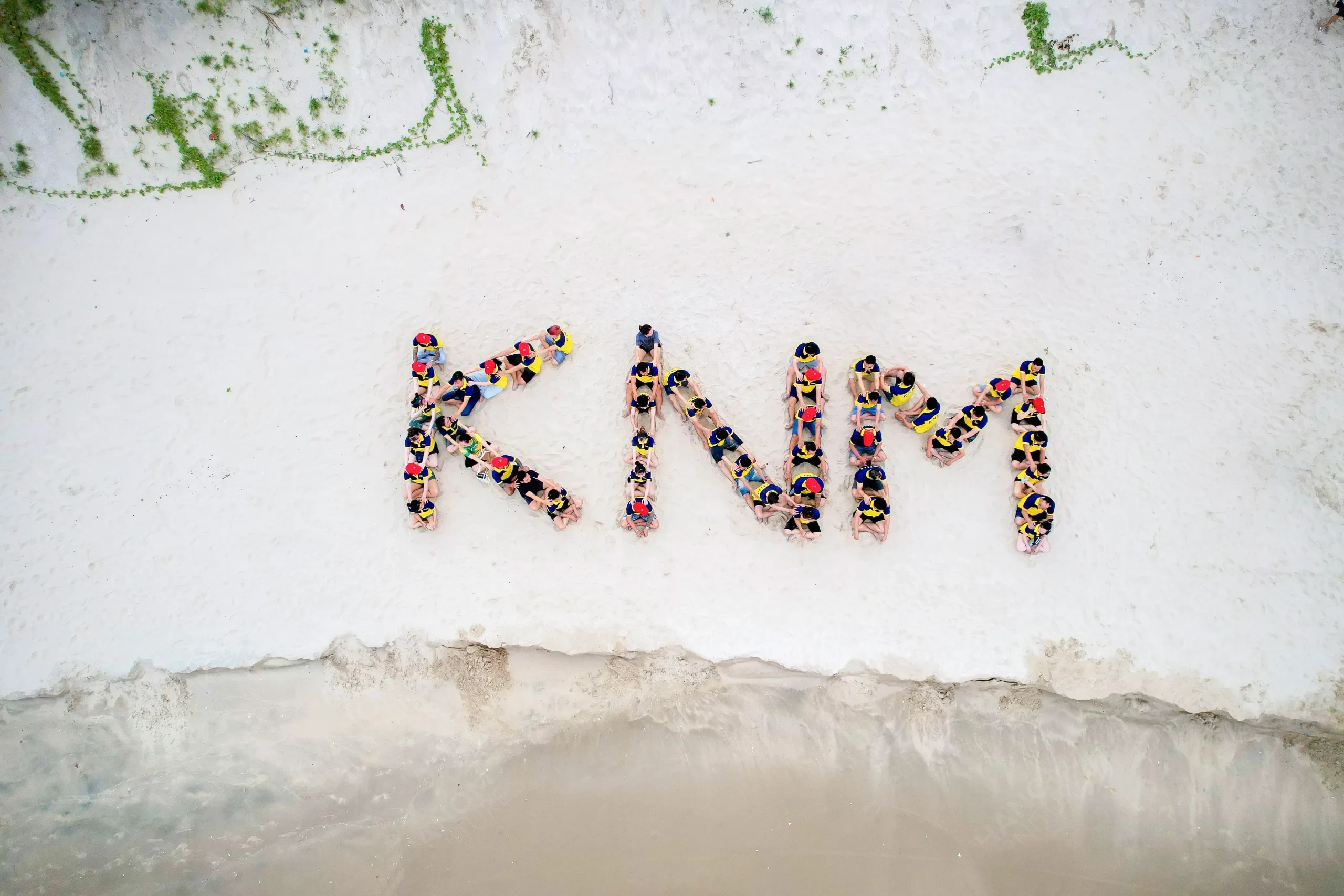 Aerial view of KNM Furniture team spelling "KNM" on Phan Thiết beach sand