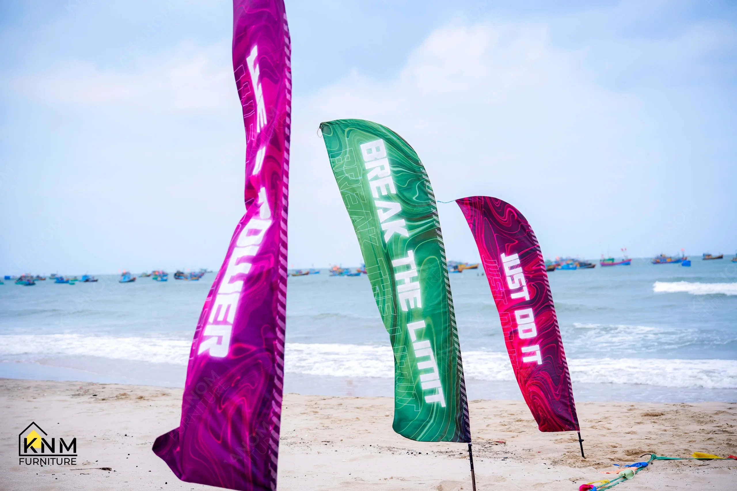 Motivational flags reading Never Give Up, Break the Limit, Just Do It on Phan Thiết beach