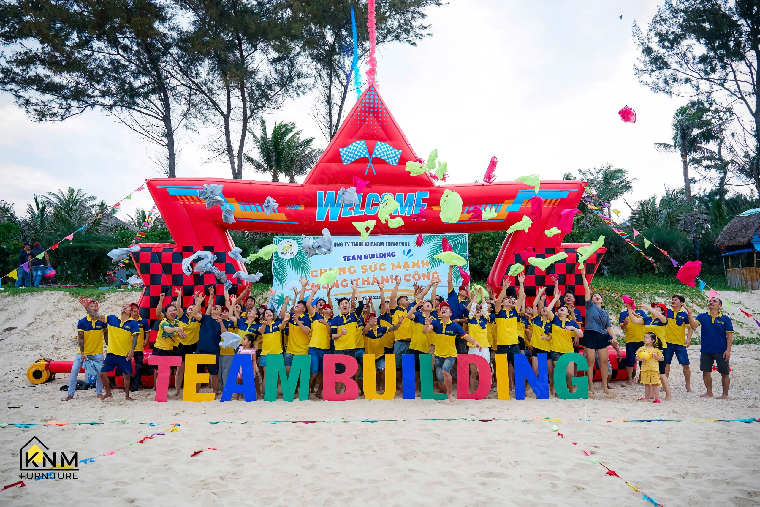 KNM Furniture team celebrating with scarves thrown in the air, Phan Thiết beach